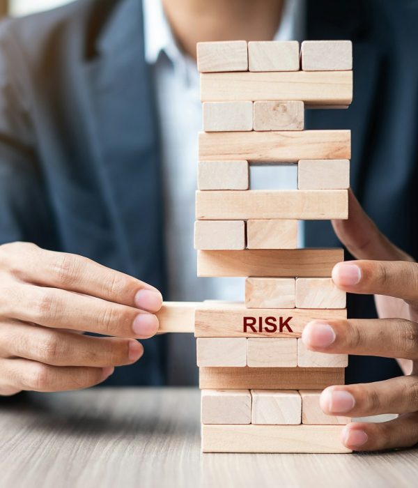 Businessman hand placing or pulling wooden block on the tower. Business planning, Risk Management,